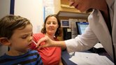 Un niño recibe una vacuna nasal para la gripe en Nueva York.