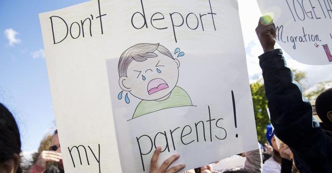 Una mujer sostiene una pancarta durante una protesta en contra de las deportaciones en frente de la Casa Blanca.