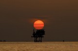 An offshore oil platform and wells are silhouetted by the setting sun in the Gulf of Mexico off the coast of Louisiana, U.S. (Derick E. Hingle/Bloomberg)