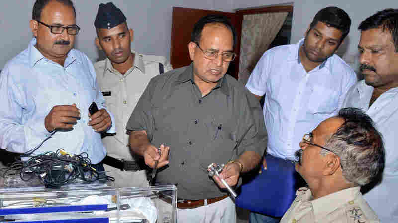 Dr. R.K. Gupta, center, the doctor who conducted sterilization procedures after which at least 13 dozen women died, is interrogated by police in Bilaspur, India, on Thursday.