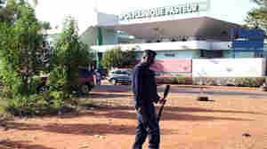 A police officer stands in front of the Pasteur clinic in Bamako, which was quarantined after a nurse there died from Ebola.