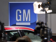 The logo of American carmaker General Motors (GM) is seen at the opening of a car show. (credit: Getty Images/Nicholas Ratzenboeck/AFP)
