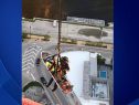 The injured construction worker being lowered down with a firefighter   on October 31,2014. (Courtesy: Miami Fire Rescue)