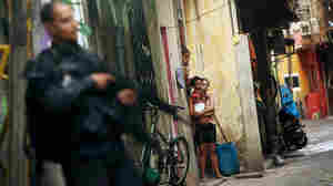Residents look on as Brazilian military police officers patrol Mare, one of the largest complexes of favelas in Rio de Janeiro, Brazil, on March 30. In one of the world's most violent countries, homicide rates are dropping — but only for whites.
