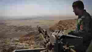 An Iraqi Kurdish Peshmerga fighter hold his position in the mountains east of Mosul.