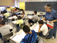 A teacher assists a student in her third-grade class. (credit: Tim Boyle/Getty Images)