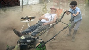 Bill Murray relaxes while Jaeden Lieberher mows his lawn in St. Vincent.