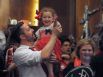 Ryan Leach holds Madeleine Schimmer, 4, as they and her mother, Sarah Schimmer, celebrate with a crowd at City Hall after the vote. 