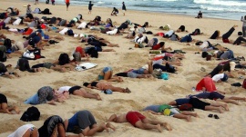 A group of around 400 demonstrators participate in a protest by burying their heads in the sand at Sydney's Bondi Beach November 13, 2014. REUTERS/David Gray