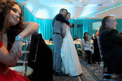 Andrew Swartz and Kelly Aronowitz Katz embrace during a presentation at their reception.