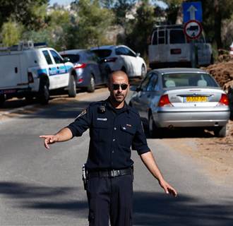 Image: An Israeli police officer gestures in the Jerusalem Forest