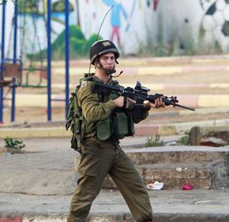 Image: Israeli army soldiers patrol during clashes with Palestinians in the early morning in the West Bank city of Jenin