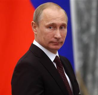 Image: Russian President Vladimir Putin walks by the Kremlin