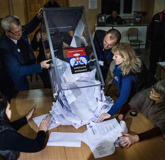 Image: Electoral workers empty a ballot box