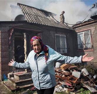 Image: Nina Anatolyevna gestures in front of her Nina Anatolyevna gestures in front of her burned house