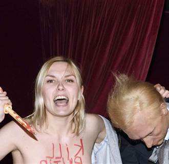 Image: An activist from the feminist group Femen holding a wax statue representing Russian President Valadimir Putin