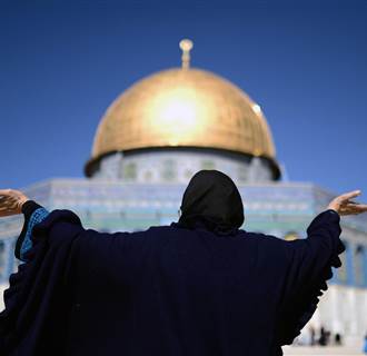 Image: A Palestinian woman reacts in front of the Al Aqsa Mosque