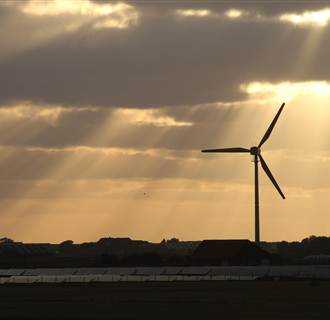 Image: Sun rays hit a wind and a solar hybrid parc on the Pellworm island, northern Germany