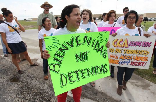 Andrea Ortiz of Austin (center) joins others in a chant for justice for immigrants at the Karnes County Residential Center near Karnes City on Saturday, Oct. 11, 2014. About 100 protesters gathered to demand the closing of the facility and for the release of immigrants detained at the facility. Photo: Kin Man Hui, San Antonio Express-News / ©2014 San Antonio Express-News