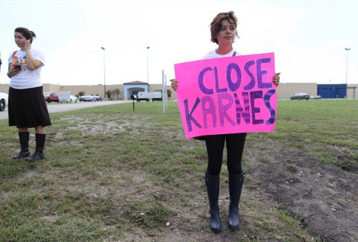 Yasmeen Davila carries a sign demanding the closing of the immigrant detainment center in Karnes City on Saturday, Oct. 11, 2014. Davila joined about 100 protesters as they rallied in front of the Karnes County Residential Center to demand the closing of the facility and for the release of immigrants detained at the center. Photo: Kin Man Hui, San Antonio Express-News / ©2014 San Antonio Express-News