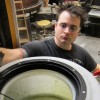 UT Research Engineer Robert Pearsal looks into a vat of algae.