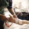 A nurse adjusts the position of a patient's arm during dialysis treatment. The treatment requires trained staff that weren't readily available in the aftermath of Hurricane Sandy.