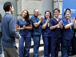 Dr. Craig Spencer, who was the first Ebola patient in New York City, is applauded by the Bellevue Hospital nursing staff as he arrives for a news conference at the hospital on Tuesday.