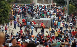 Teachers march around a vehicle they flipped during clashes with riot police Tuesday in Chilpancingo, the capital of Guerrero state, Mexico. Associated Press