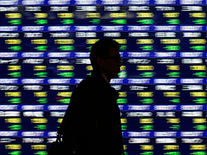 A man walks past an electronic stock quotation board outside a brokerage in Tokyo January 14, 2014. Caption|REUTERS/Issei Kato