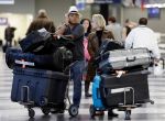 FILE - In this Dec. 1, 2013 file photo, travelers walk through terminal 3 baggage claim at O'Hare International airport in Chicago. The government reported Monday, May 5, 2014, that U.S. airlines raised $3.35 billion from bag fees in 2013, down 4 percent from 2012. That's the biggest decline since fees to check a bag or two took off in 2008. (AP Photo/Nam Y. Huh, File)