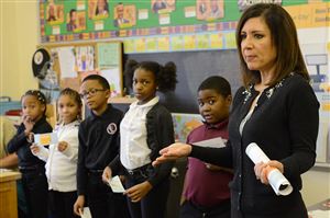  Huntington Bank Community Development Manager Lisa Quattrochi teaches third graders at the Sister Thea Bowman Catholic Academy in Wilkinsburg about money and banking during a Junior Achievement program at the school. 