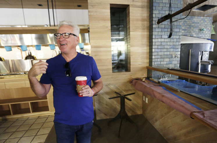 Former Rays manager Joe Maddon walks through his Tampa restaurant, Ava, on Thursday. [JAMES BORCHUCK  |  Times]