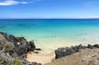 At Hapuna Beach in Hawaii, the sound of the sea lapping at the shore mixes with the laughter of sunbathers