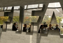 Journalists are reflected in a logo at the FIFA headquarters after a meeting of the executive committee in Zurich October 4, 2013. REUTERS/Arnd Wiegmann  