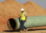 Date: 10/04/2012 Location: Sumner, Texas Description: A pipeline worker walks the length of a pipe as work continues. Oil has long lived in harmony with farmland and cattle across the Texas landscape, a symbiosis nurtured by generations and built on an unspoken honor code that allowed agriculture to thrive while oil was extracted.  © AP Image/Tony Gutierrez