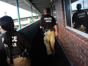 Parole Officers Crystal Thomas, left, and Ryan Burch walk toward a parolee's room at the Riviera Motel in Aurora, Colorado, on Aug. 7, 2013.