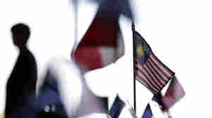 A Malaysian flag sits on a table among other flags during a news conference at the Trans-Pacific Partnership Free Trade Agreement talks in July 2012 in San Diego. Nearly two and a half years later, the deal remains incomplete.