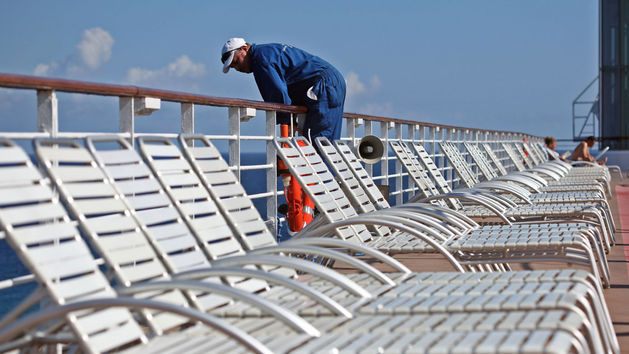 A worker leans over a railing on the Celebrity Constellation cruise ship while docked in Falmouth, Jamaica, on Monday, Dec. 17, 2012.