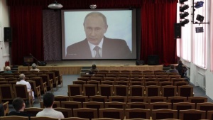 Employees and residents of the retirement home watch a TV broadcast showing Russia’s President Vladimir Putin delivering his annual state of the union speech to members of parliament and other top officials in the Kremlin, in Stavropol, December 4, 2014. REUTERS/Eduard Korniyenko
