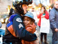 Nov. 25, 2014 photo provided by Johnny Nguyen, Portland police Sgt. Bret Barnum, left, and Devonte Hart, 12, hug at a rally in Portland, Ore., where people had gathered in support of the protests in Ferguson, Mo. (AP Photo/Johnny Huu Nguyen)