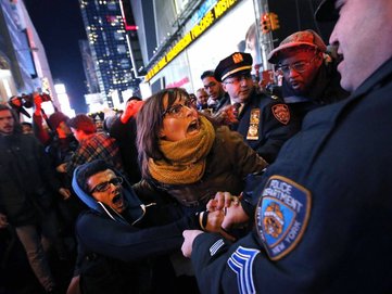 FILE - In this Dec. 4, 2014, file photo, police make arrests after protesters rallying against a grand jury´s decision not to indict the police officer involved in the death of Eric Garner attempted to block traffic at the intersection of 42nd Street and Seventh Avenue near Times Square, in New York. Officers say the outcry has left them feeling betrayed and demonized by everyone from the president and the mayor to throngs of protesters who scream at them on the street. "Police officers feel like they are being thrown under the bus," said Patrick Lynch, president of the police union. (AP Photo/Jason DeCrow, File)