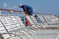 A worker leans over a railing on the Celebrity Constellation cruise ship while docked in Falmouth, Jamaica, on Monday, Dec. 17, 2012.