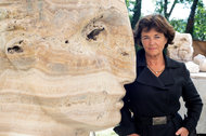 Emily Young with one of her seemingly half-finished, monumental heads on the grounds of the Convent of Santa Croce in Tuscany, where she lives and sculpts using a wide variety of stones.
