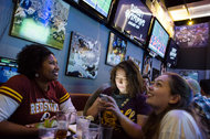 From left, Adrienne Allen, Becca Garrison and Laura Tipton watch N.F.L. action and check their fantasy football progress at the Promenade Bar and Grill in Manhattan.