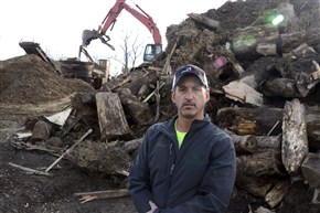  Eric Vaccarello , president of Land Clearing Specialists Inc., stands near stumps and woodwaste placed in a "grinder" making wood chips. Vaccarello owns one of the largest land-clearing and reclamation services operating in the Marcellus and Utica Shales areas.