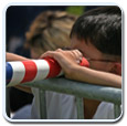 John Kerry Offices page.  Child looks through flag.