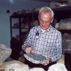 Scientist Emeritus John Pojeta examining Cretaceous rudist clams.