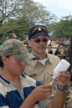 Left to right: A fourth-year Nicaraguan veterinary student and LCDR Gregory Langham, veterinarian, USPHS, are about to vaccinate Brahma cattle.