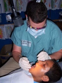 LT Charles Brucklier, HHS U.S. Public Health Service Commissioned Corps dental hygienist, places dental sealant on a boy in Delfina Rivas, El Salvador. (Photo provided by LT Charles Brucklier, USPHS.)