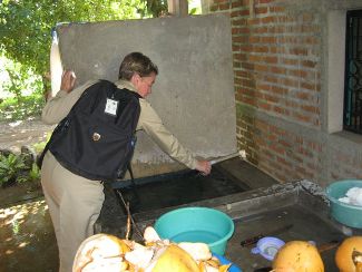CAPT Cynthia Kunkel, HHS U.S. Public Health Service Environmental Health Officer, collects a water sample at a house near Costa Brava in El Salvador. (Photo provided by CAPT Kunkel.) 